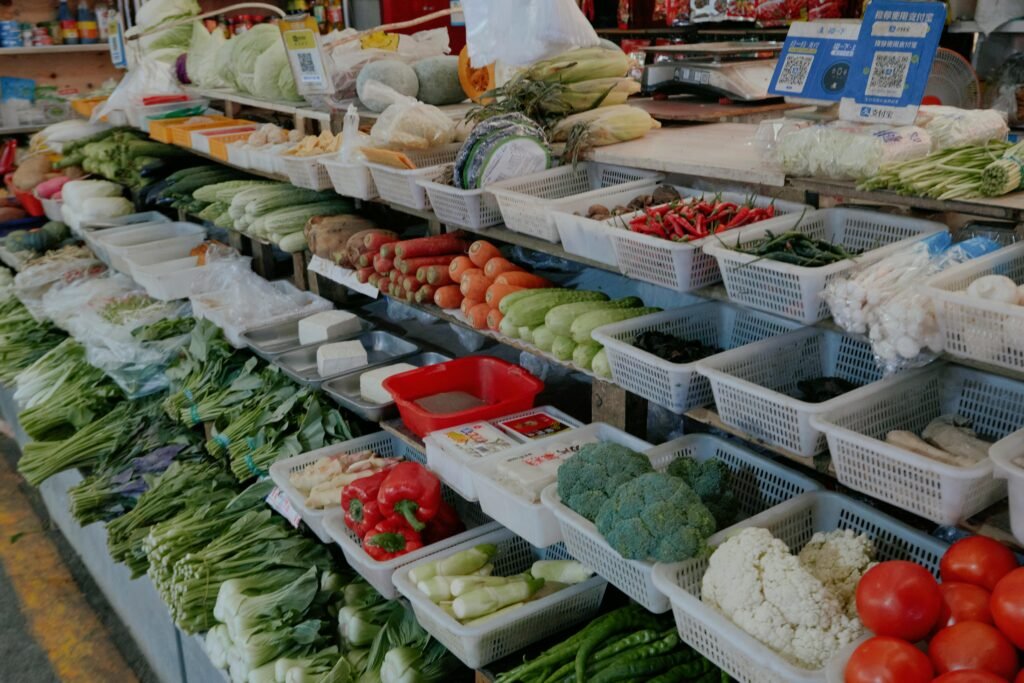 Colorful assortment of fresh vegetables at an outdoor market stall.